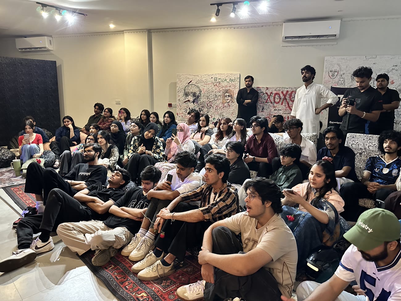 The audience watching intently at the mehfil